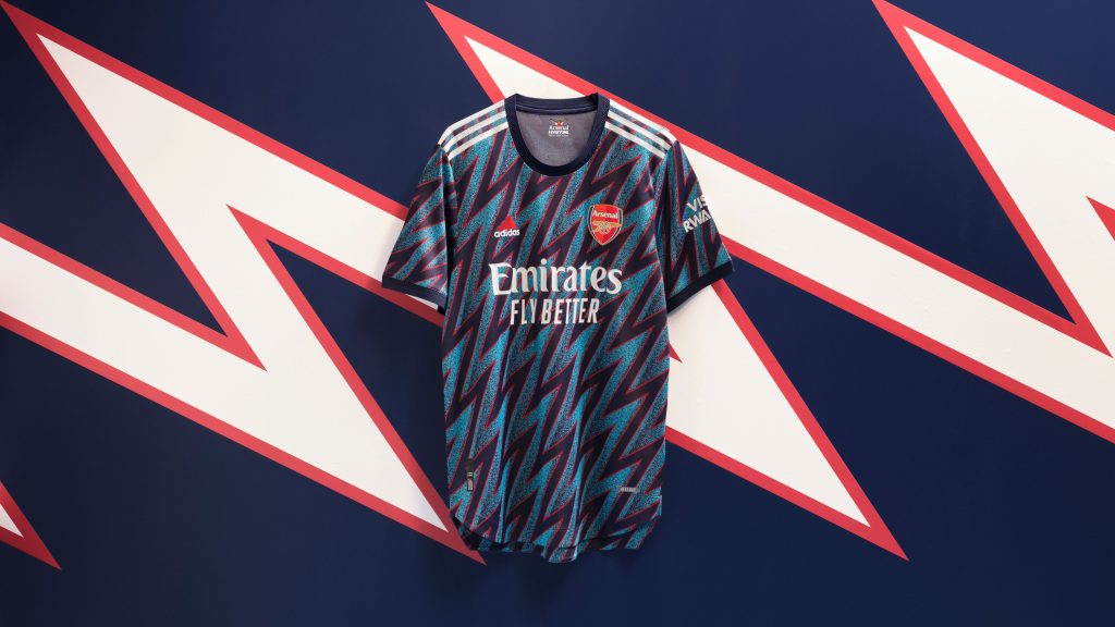 Troisième maillot 2021-2022 d’Arsenal à motifs, sponsor Emirates Fly Better, devant un éclair rouge et blanc