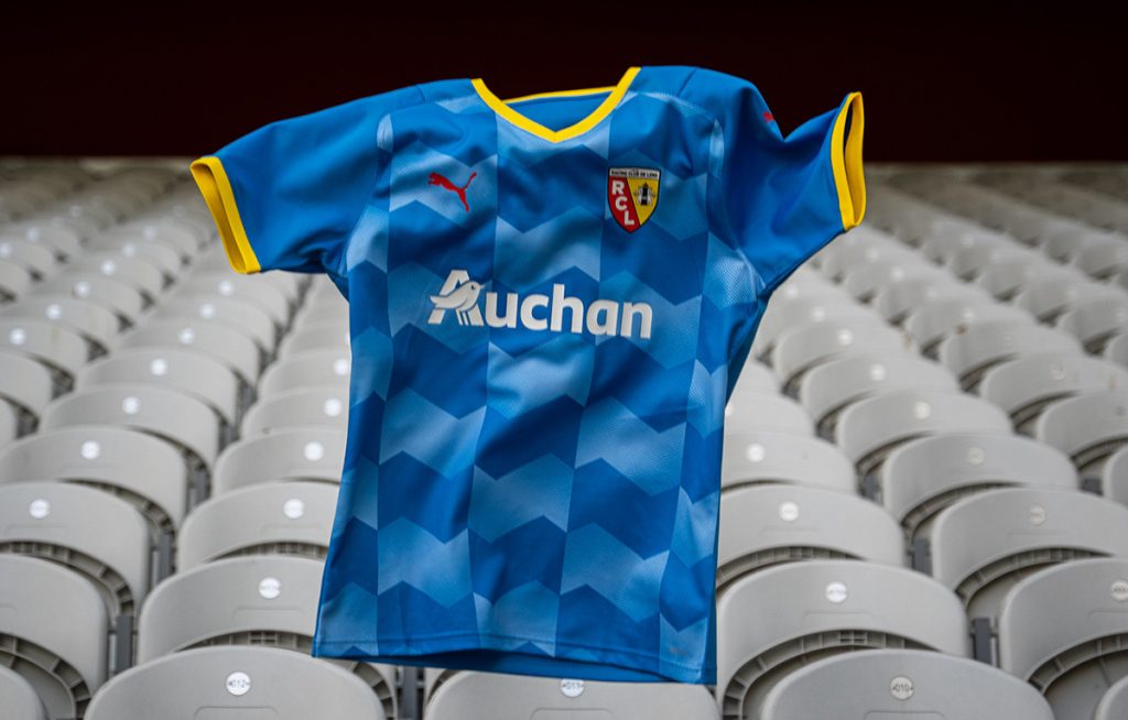 Troisième maillot bleu 2021-2022 du RC Lens, sponsor Auchan, posé sur des sièges de stade