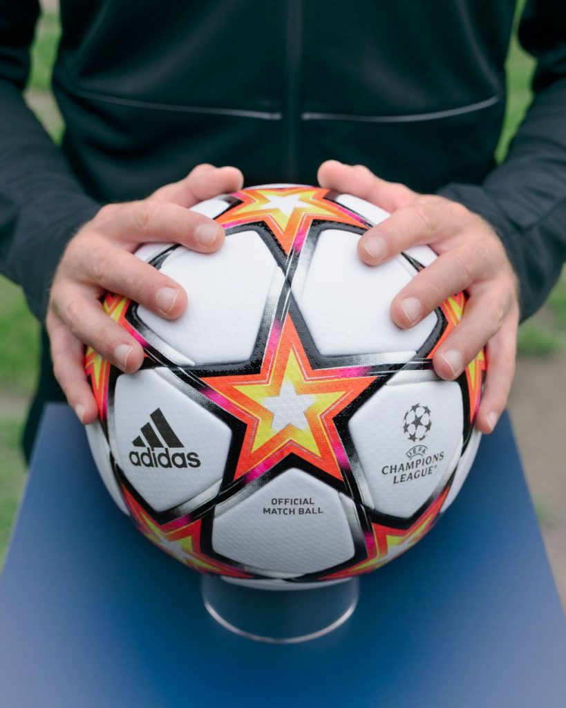 Mains tenant le ballon adidas de la Ligue des champions 2021-2022