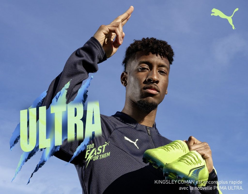 Joueur montrant une chaussure de football Puma Ultra Ultimate jaune fluo devant l’inscription « Ultra »